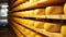 Yellow Dutch Cheese Wheels Aging on Wooden Shelves in Cheese Factory