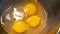 Yellow eggs on metallic bowl. Three chicken egg yolks. Preparation for scrambled eggs in a metal bowl. Cooking eggs