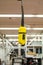 Yellow electric remote crane operating switch module hanging by its wire from the ceiling of a science laboratory