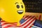 Yellow emoji balloons on the background of the board with the event inscription and American flags.