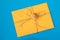 Yellow envelope tied with twine and a seashell on a blue background