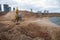 Yellow Excavator at building under construction. Backhoe digs the ground for the foundation and for laying sewer pipes