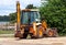 Yellow excavator, bulldozer machine and worker tractor. Road works. Road machinery at construction site.