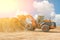 Yellow excavator on a construction site against blue sky. wheel loader at sandpit during earthmoving works