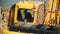 Yellow excavator digs rubbles of broken building at site