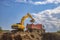 Yellow excavator and empty dump truck