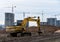 Yellow excavator during groundwork on construction site. Hydraulic backhoe on earthworks.