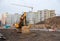 Yellow excavator during groundwork on construction site. Hydraulic backhoe on earthworks.