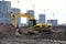 Yellow excavator during groundwork on construction site. Hydraulic backhoe on earthworks. Heavy equipment