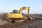 Yellow excavator during groundwork on construction site. Hydraulic backhoe on earthworks. Heavy equipment