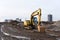 Yellow excavator during groundwork on construction site. Hydraulic backhoe on earthworks. Heavy equipment