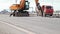 Yellow excavator with hydraulic hammer is building a highway