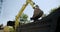 Yellow Excavator load ground in transportation truck. Close up