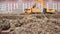 Yellow excavator loads clay using its big bucket