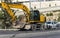 Yellow excavator machine with risen boom construction site