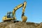 Yellow excavator on sand hill