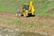 Yellow excavator tractor on the riverbed