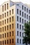 The yellow facade of the city office building with windows. Sunset lighting