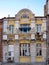 Yellow facade of the house built in the first quarter of the last century decorated with white statues of children