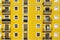 Yellow facade. Some aligned apartment windows making rows.