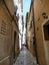 YELLOW FACADES IN A NARROW COBBLESTONE STREET IN POREC, CROATIA