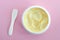 Yellow facial mask banana face cream, shea butter hair mask, body butter. Natural skin and hair concept. Pink background.