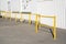 Yellow fences for walkway close to white wall of factory