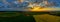 Yellow field of corn at sunset next to an village, idyllic aerial landscape.