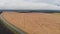 Yellow field Dense clouds paved road aerial view