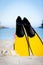 Yellow fins and snorkelling mask on beach in summer