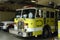 Yellow Fire trucks sit inside the Fire station house