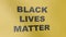 Yellow flag with the inscription: Black Lives Matter. The flag is developing in the wind. Protests against racism concept.