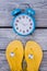 Yellow flip flops and blue alarm clock.