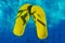 Yellow flip-flops floating in a swimming pool, a top view