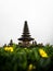 Yellow flower green plant frame of Pura Ulun Danu Beratan hindu Shiva water temple in Bedugul lake Bratan Bali Indonesia