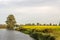 Yellow-flowering rapeseed in a Dutch field next to a narrow meandering river