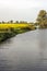 Yellow-flowering rapeseed in a Dutch field next to a narrow meandering river