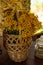 Yellow flowers of tansy in a basket on the veranda. Vertical photo of rural still life