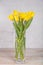 Yellow flowers, tulips in a vase. On a light background. Congratulations on Easter