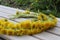 Yellow flowers in a wreath on a wooden background