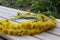 Yellow flowers in a wreath on a wooden background