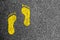 Yellow footprints on asphalt
