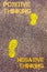 Yellow footsteps on sidewalk from Negative Thinking to Positive Thinking message. Concept image