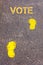 Yellow footsteps on sidewalk towards Vote message