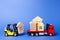 A yellow forklift loads a house figures on a red truck. Concept of transportation and cargo shipping, moving company. Construction