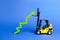 A yellow forklift raises a big green arrow up. Growth in production rates and development of industry and infrastructure