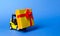 Yellow forklift truck carries a golden yellow gift box with a red bow. Purchase and delivery of a present. retail, discounts