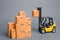 Yellow Forklift truck raises a cardboard box to the top of a stack pile of boxes. Warehouse, stock. commerce, retail. E-commerce