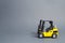 Yellow forklift truck side view on gray background. Warehouse equipment, vehicle. Unloading, transportation, sorting, loading