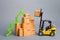 Yellow Forklift truckraises a box over a stack of boxes and a green arrow up. High trade volumes, increased production, storage